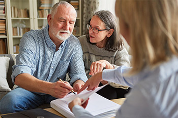 Elderly Couple Discussion With Lawyer looking at paperwork